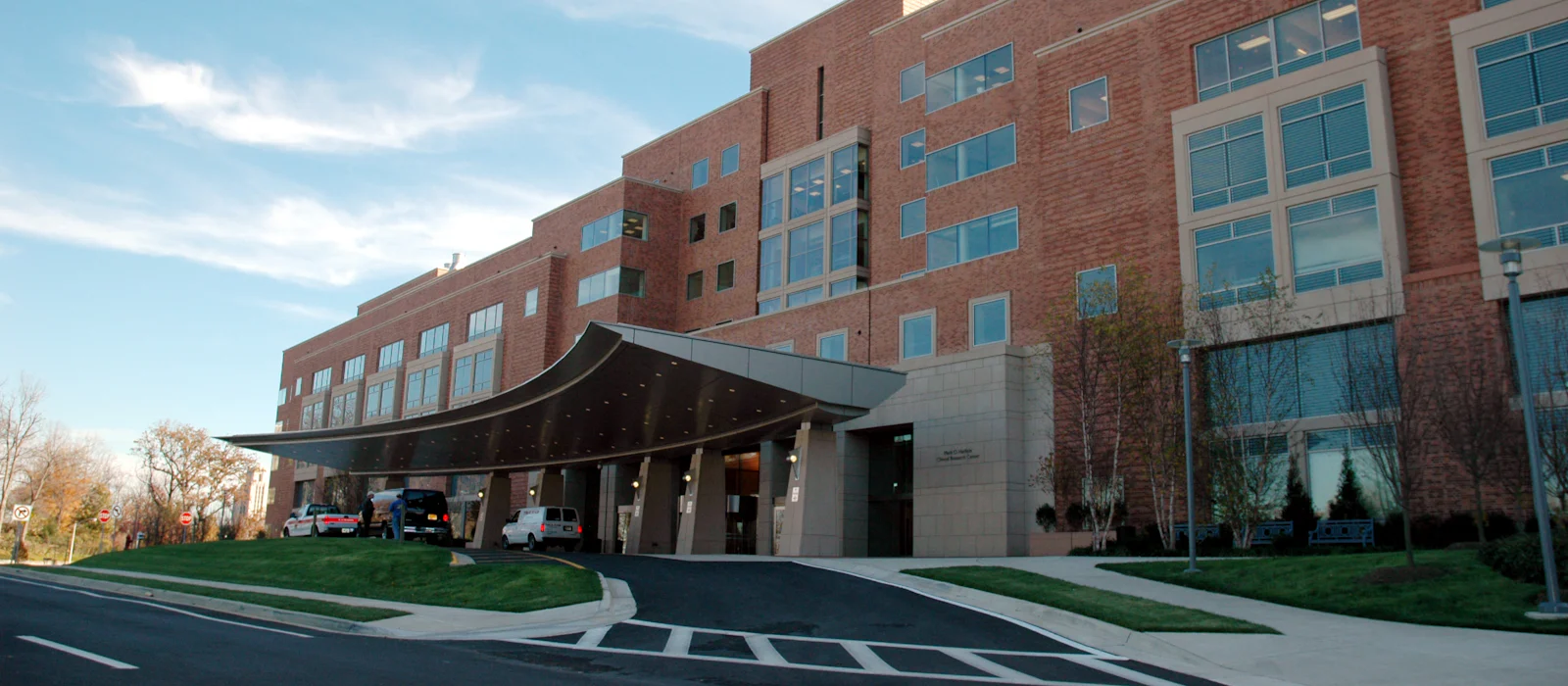 Multi-story brick healthcare building with a curved covered entrance.