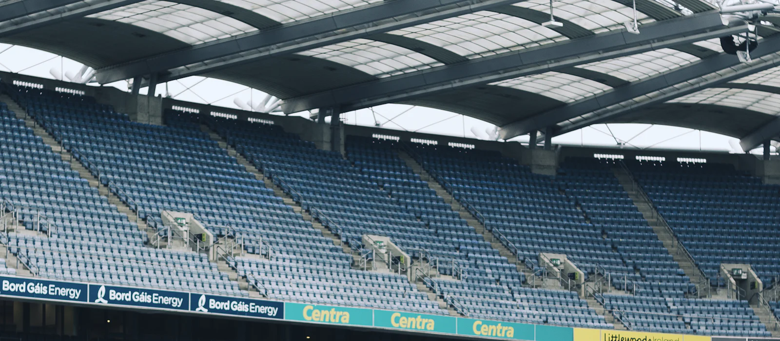 Rows of stadium seats beneath a translucent canopy roof.
