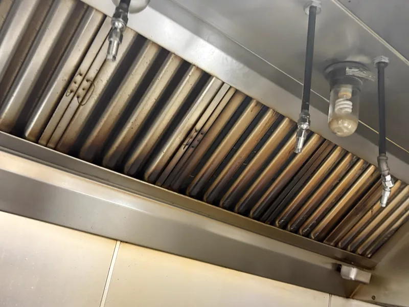 Brewery hood canopy before cleaning, grease-darkened filter bank, Georgetown.