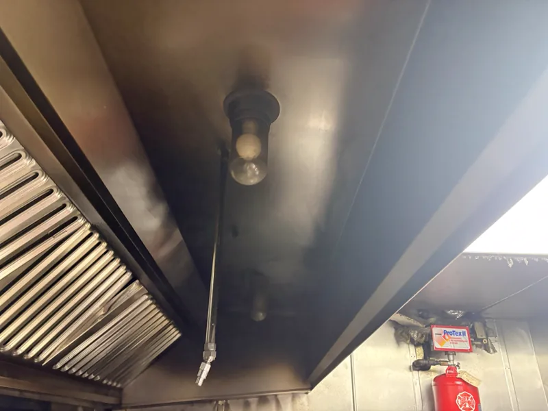 Restaurant hood canopy before cleaning, soot darkening the canopy, light fixtures, and filters, Denver.