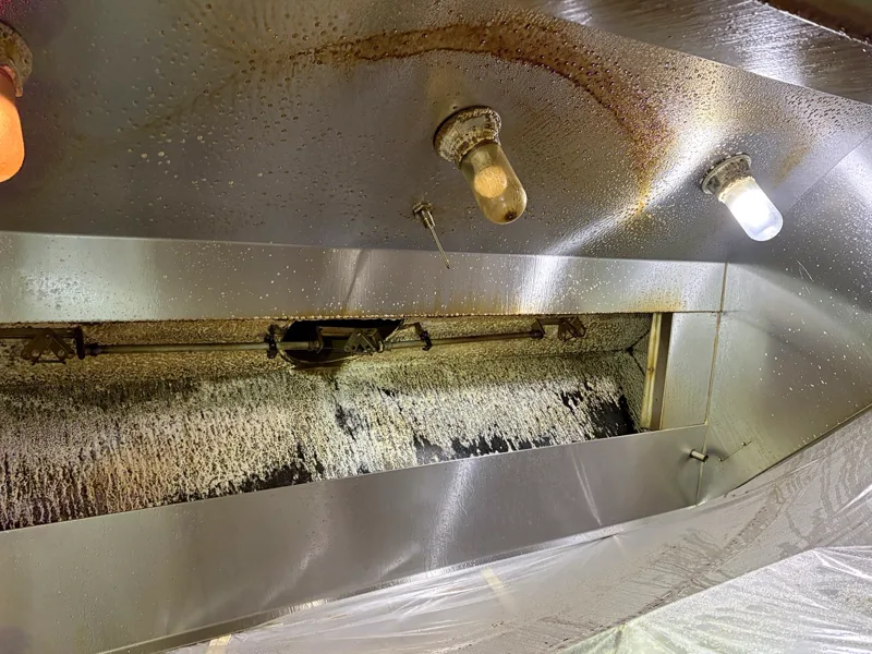 Grocery store hood plenum before cleaning, grease and residue coating the filter slot, Glenwood Springs.