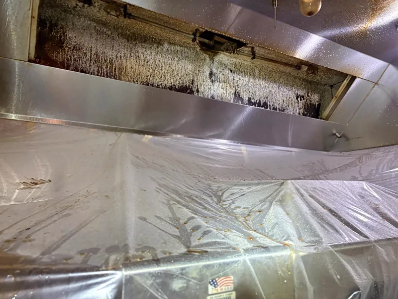 Grocery store hood plenum before cleaning, grease buildup on the filter slot, Glenwood Springs.