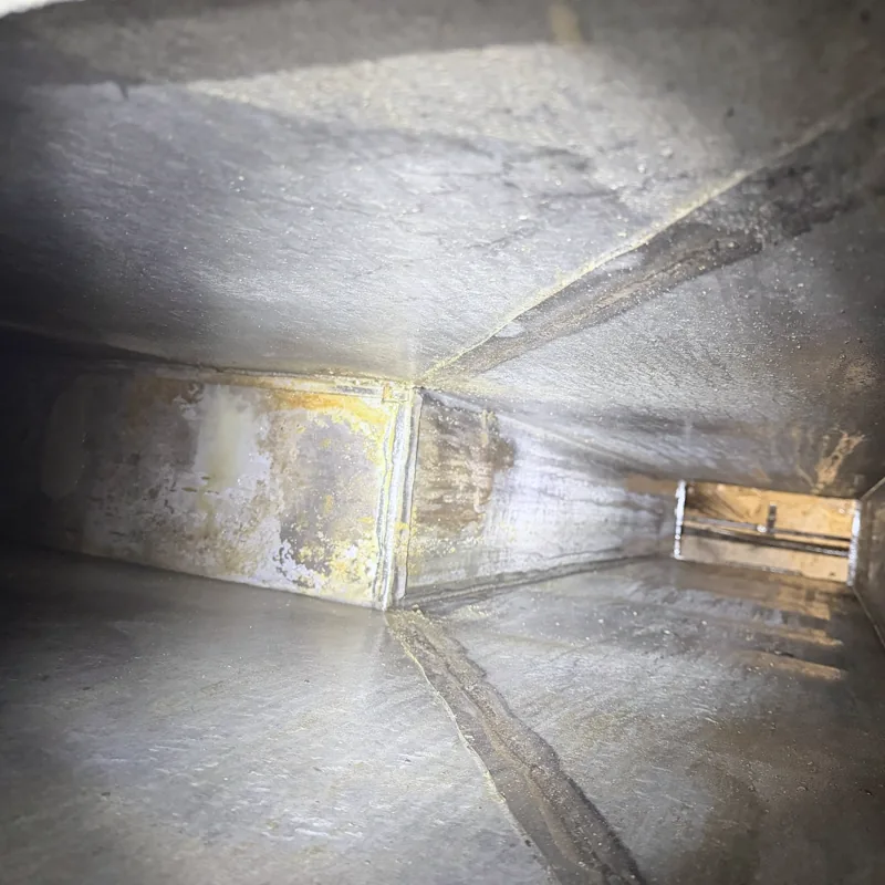 Hotel kitchen exhaust duct after cleaning, walls clean and bare metal visible, Cheyenne, Wyoming.