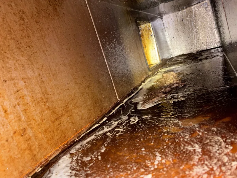 Entertainment venue exhaust duct before cleaning, rust-brown grease and suds on the walls, Centennial.