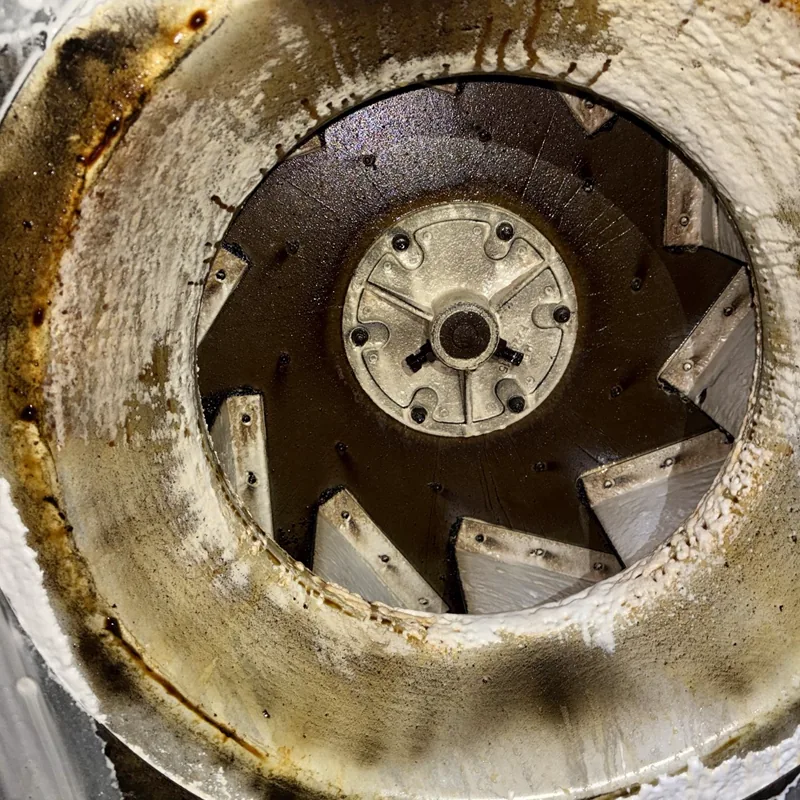 Restaurant exhaust fan wheel before cleaning, grease caked on the blades and housing, Denver.